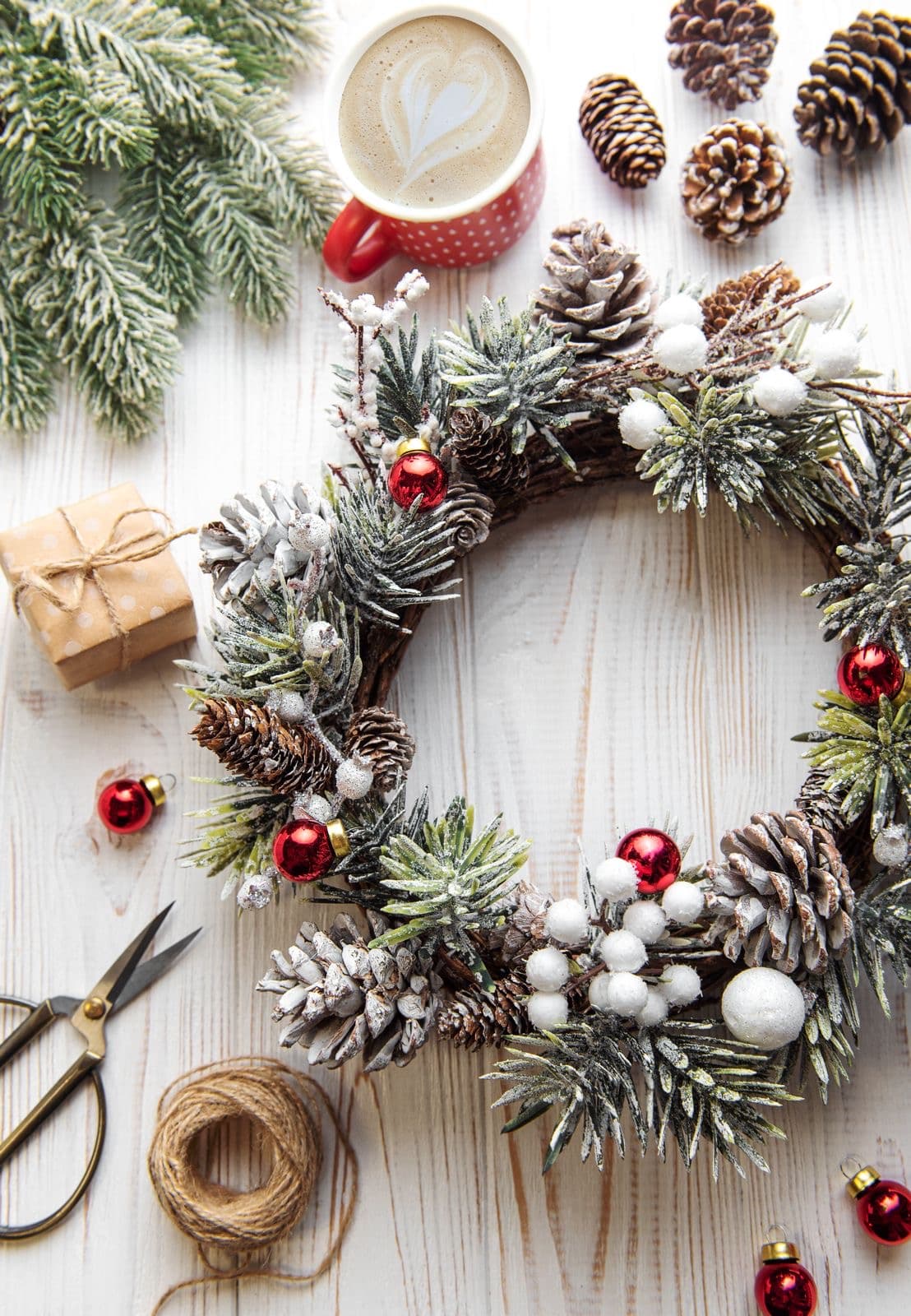 Hands crafting a Christmas wreath at a festive workshop